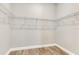 Walk-in closet with white wire shelving and wood floor at 7789 Nemours Pkwy, Orlando, FL 32827