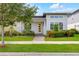 Charming single Gathering home showcasing a modern architectural style, professional landscaping, and a bright yellow front door at 7789 Nemours Pkwy, Orlando, FL 32827