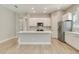 Bright, open kitchen with a large island, stainless steel appliances and light wood floors at 7789 Nemours Pkwy, Orlando, FL 32827