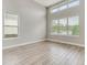 A serene living space with large windows, providing natural light and showcasing the light wood flooring at 7789 Nemours Pkwy, Orlando, FL 32827