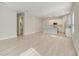 Open living space with light wood floors connecting to kitchen at 7789 Nemours Pkwy, Orlando, FL 32827