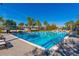 Large pool with lane markers and lounge chairs, surrounded by palm trees, for outdoor enjoyment at 7789 Nemours Pkwy, Orlando, FL 32827