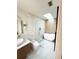 Sleek bathroom showcasing a glass enclosed shower and a freestanding tub beneath a skylight at 7813 Delphia St, Orlando, FL 32807