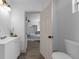 View from a bathroom looking into a bedroom. The bathroom has a white vanity and toilet at 7813 Delphia St, Orlando, FL 32807