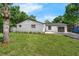 A single-Gathering home with a well-manicured lawn and a mature tree in the front yard at 7813 Delphia St, Orlando, FL 32807
