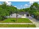 Charming single-story home with well-manicured lawn, mature trees, and brick exterior at 7813 Delphia St, Orlando, FL 32807