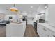 Modern, well-lit kitchen featuring white cabinets, stainless steel appliances and a large island counter at 7813 Delphia St, Orlando, FL 32807