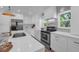 Bright kitchen featuring stainless steel appliances, white cabinetry, and quartz countertops at 7813 Delphia St, Orlando, FL 32807