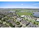 Expansive aerial view of the neighborhood featuring lush landscaping, a scenic lake, and nearby amenities at 8436 Tavistock Lakes Boulevard, Orlando, FL 32827