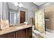 Bathroom features a granite countertop, dark wood cabinets, and a shower with tiled walls at 8436 Tavistock Lakes Boulevard, Orlando, FL 32827