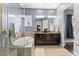 A luxurious bathroom featuring a soaking tub, glass-enclosed shower, and dual vanities at 8436 Tavistock Lakes Boulevard, Orlando, FL 32827