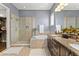 Elegant bathroom with dual sinks, walk-in shower, and a soaking tub for relaxation at 8436 Tavistock Lakes Boulevard, Orlando, FL 32827
