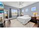 Bright bedroom with a ceiling fan, large windows, and hardwood floors at 8436 Tavistock Lakes Boulevard, Orlando, FL 32827