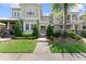 Inviting townhome with manicured landscaping, lush green lawn, and a stone pathway leading to the front entrance at 8436 Tavistock Lakes Boulevard, Orlando, FL 32827