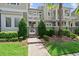Beautiful townhome with manicured landscaping, featuring a stone path and lush greenery around the entrance at 8436 Tavistock Lakes Boulevard, Orlando, FL 32827