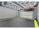 Spacious garage featuring modern lighting, a checkered floor, and overhead storage racks for optimal organization at 8436 Tavistock Lakes Boulevard, Orlando, FL 32827