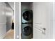 Modern laundry area with stacked washer and dryer units, maximizing space and efficiency at 8436 Tavistock Lakes Boulevard, Orlando, FL 32827