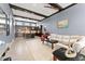 Open-concept living room featuring a comfortable sofa, coffered ceiling, and seamless flow to the modern kitchen at 8436 Tavistock Lakes Boulevard, Orlando, FL 32827