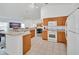 Bright kitchen featuring tile floors, light wood cabinets and white appliances at 941 Clear Creek Cir, Clermont, FL 34714