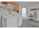 Functional laundry room equipped with a washer, dryer, shelving, and a sleek epoxy floor finish at 941 Clear Creek Cir, Clermont, FL 34714