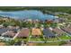 Community view with single Gathering homes, many trees, lawns and a lake at 9836 Lake District Ln, Orlando, FL 32832