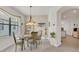 Bright dining room featuring a glass table, chandelier, and a view into the kitchen at 9836 Lake District Ln, Orlando, FL 32832