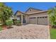 Charming home with a well-manicured lawn, brick paved driveway, neutral paint, shutters, and an attached garage at 9836 Lake District Ln, Orlando, FL 32832