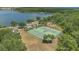 Aerial view of tennis courts near a lake, surrounded by lush greenery and community amenities at 9836 Lake District Ln, Orlando, FL 32832