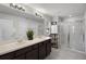 Bathroom with double sinks, a large mirror, and glass shower door at 1165 Stratton Ave, Groveland, FL 34736