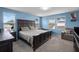 Spacious primary bedroom with ample natural light and a comfortable lounge chair at 1165 Stratton Ave, Groveland, FL 34736