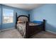 Inviting bedroom with bright blue walls, a large bed, and a window bringing in natural light at 1165 Stratton Ave, Groveland, FL 34736