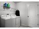 Functional laundry room equipped with modern washer and dryer units and upper storage shelves, ready for efficient laundry tasks at 1165 Stratton Ave, Groveland, FL 34736