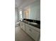 Bathroom featuring a double sink vanity with granite countertops, modern fixtures, and tile floors at 1190 Seaside Mist Trl, Kissimmee, FL 34747