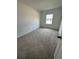 Bright bedroom features neutral carpet, a window letting in natural light, and white walls at 1190 Seaside Mist Trl, Kissimmee, FL 34747