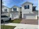 Inviting exterior view of modern two-story home with brick driveway, well maintained lawn, and attached garage at 1190 Seaside Mist Trl, Kissimmee, FL 34747