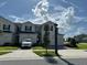 Inviting two-story townhome with manicured lawn, private driveway, and beautiful blue sky at 1190 Seaside Mist Trl, Kissimmee, FL 34747