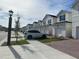 A row of elegant, stucco-clad townhouses with uniform architectural details line a beautifully landscaped street at 1190 Seaside Mist Trl, Kissimmee, FL 34747