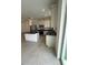 Well-lit kitchen featuring stainless steel appliances, center island with dark granite countertops, and tile flooring at 1190 Seaside Mist Trl, Kissimmee, FL 34747