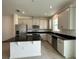 Modern kitchen featuring stainless steel appliances, center island with dark granite countertops and tile flooring at 1190 Seaside Mist Trl, Kissimmee, FL 34747