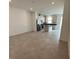 Open concept living space flowing into a modern kitchen with stainless steel appliances, light cabinets, and tile floors at 1190 Seaside Mist Trl, Kissimmee, FL 34747