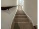 Clean, carpeted staircase leading upstairs with a wooden handrail and white walls on either side at 1190 Seaside Mist Trl, Kissimmee, FL 34747