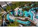 Aerial view of a resort-style water park with lazy river, slides, and lush tropical landscaping at 1283 Blue Paradise Way, Clermont, FL 34714