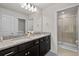 Bathroom featuring double sinks, granite counters and glass shower enclosure at 1283 Blue Paradise Way, Clermont, FL 34714