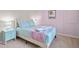 Cozy bedroom with pastel pink wall, plush bedding, and neutral carpeting at 1283 Blue Paradise Way, Clermont, FL 34714