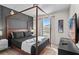 A primary bedroom features a four poster bed, a large window, and decorative accents at 1283 Blue Paradise Way, Clermont, FL 34714