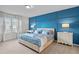 Bright bedroom with blue accent wall, plush bedding, and neutral carpeting at 1283 Blue Paradise Way, Clermont, FL 34714