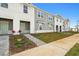 Attractive townhome with a tidy lawn and paved walkway leading to the front door at 1283 Blue Paradise Way, Clermont, FL 34714