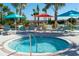 Relaxing hot tub surrounded by lounge chairs, umbrellas, and lush landscaping with hammocks at 1283 Blue Paradise Way, Clermont, FL 34714