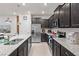 Modern kitchen features a large island with granite countertops, stainless appliances and dark cabinets at 1283 Blue Paradise Way, Clermont, FL 34714