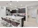 Open kitchen features a large granite island with seating, stainless appliances and dark cabinetry at 1283 Blue Paradise Way, Clermont, FL 34714